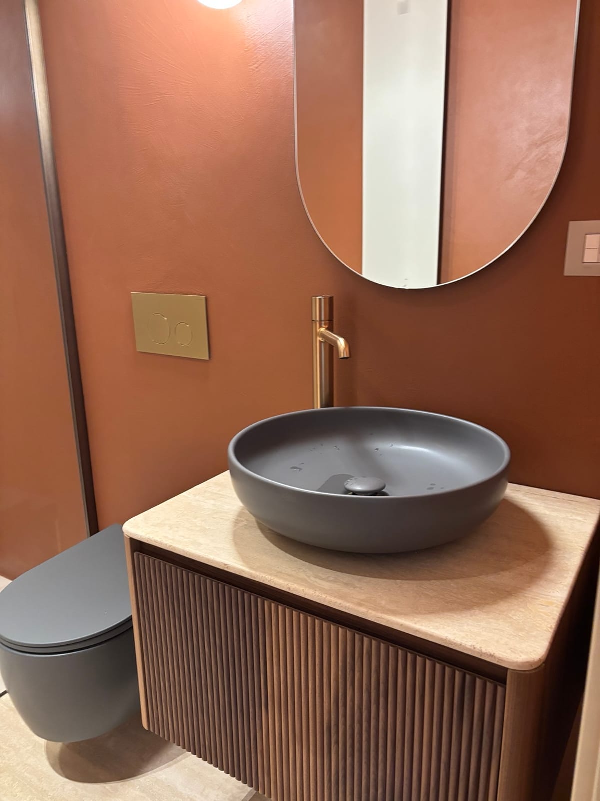 Bagno con lavabo, mobile in legno e rubinetteria dopo la pulizia
