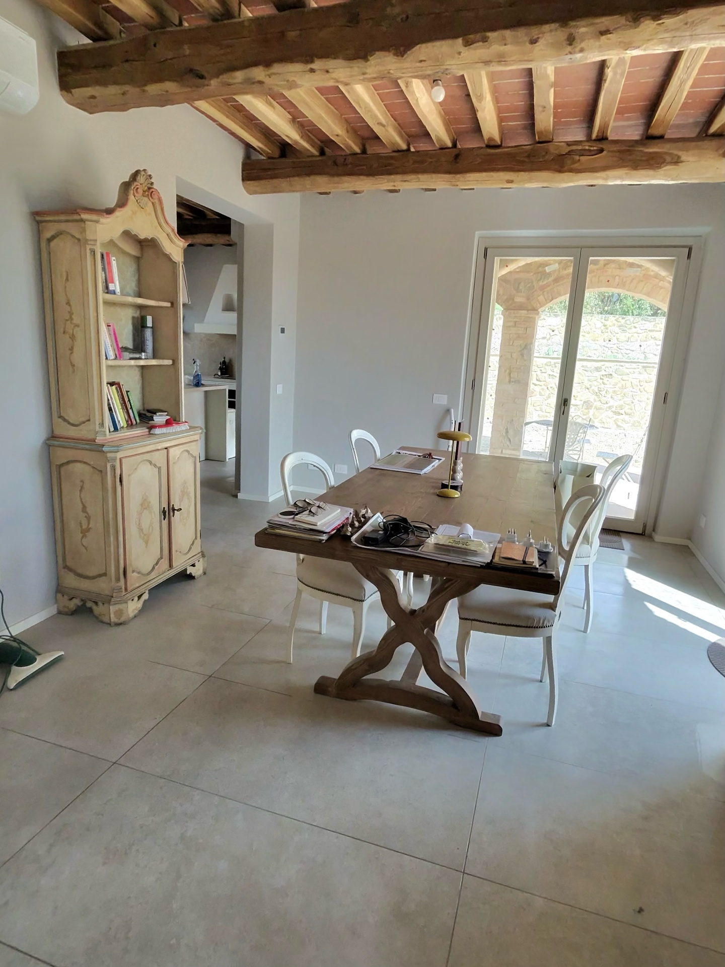 Sala da pranzo con travi a vista, soffitto in cotto e tavolo rustico in un agriturismo a Montalcino dopo l'intervento di pulizia post cantiere J&D Clean Service.