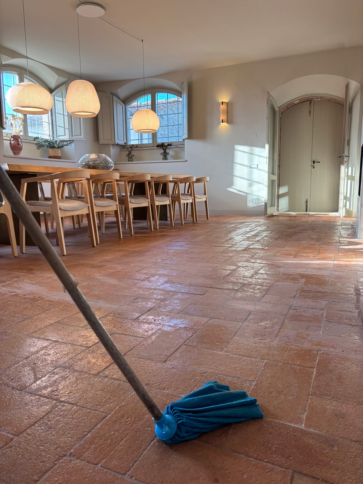 Sala da pranzo con pavimento in cotto durante il lavaggio con mop